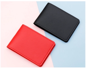 Slim leather card holder showing fine stitching detail and textured finish in black and red