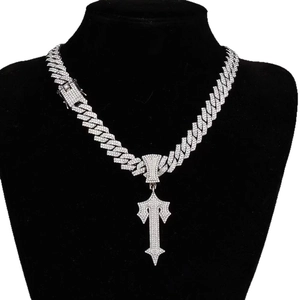 Silver iced out dagger cross pendant necklace with Cuban chain on a black bust mannequin