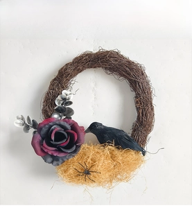 Detail of gothic Halloween wreath with black rose, realistic crow and a tiny spider