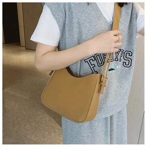 Close-up of a camel hobo shoulder bag featuring adjustable metal buckle and zipper closure