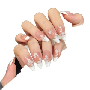 Faux ongles stiletto french blancs avec fleurs 3D et perles argentées élégantes