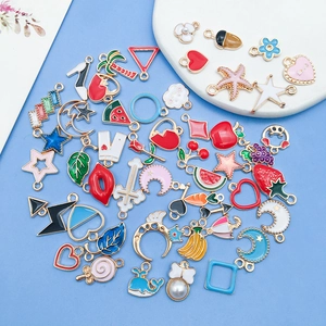 Macro shot of colorful enamel alloy charms for DIY jewelry making on a blue background
