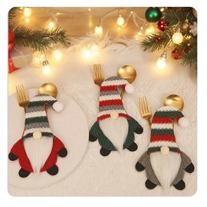 Three-piece Christmas gnome cutlery holders with striped hats on a cozy festive table
