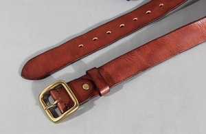 Detailed macro view of retro brass buckle and premium leather texture on a men's belt