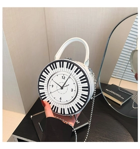 Detail of round handbag featuring black and white piano keys and clock face design