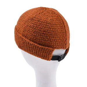 Detail of adjustable black strap buckle on caramel knit docker cap for winter warmth