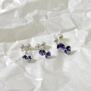 Detailed view of three pairs of silver magnetic earrings with purple zircon in various sizes