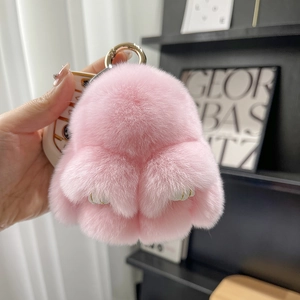 Detailed close-up of a pink plush bunny fur keychain with metal ring and leather tag
