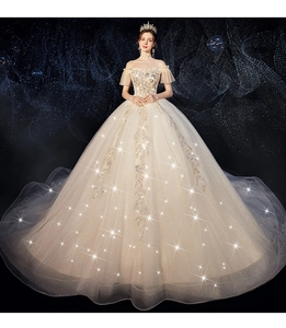 Detailed close-up of champagne gold bridal gown with intricate beadwork and shimmering sequins