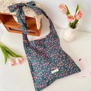 Detail of floral hobo bag featuring large decorative shoulder bow and pink tulip scene