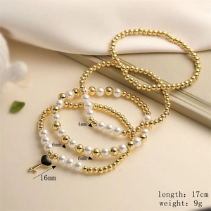 Detail of layered gold and pearl bracelet with heart key charm and size dimensions