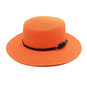 Détail de chapeau canotier en paille orange avec sangle en cuir noir et boucle en métal argenté
