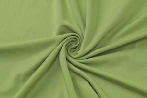 Macro detail of grass green ribbed knit fabric showing texture and elasticity