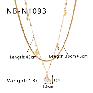 Detail of double-layer gold necklace showing shell butterfly pendant and ball chain specs