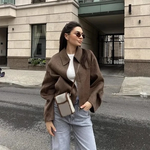 Street style view of a brown vintage zipper jacket with long sleeves and classic lapels