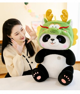 Close-up van een grote schattige panda knuffel in een groen drakenpak getoond met model