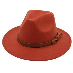 Close-up detail of orange-red wool fedora hat with premium brown leather belt buckle strap