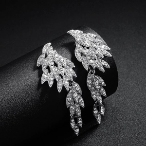Sparkling silver wing drop earrings with white crystal rhinestones on a black background