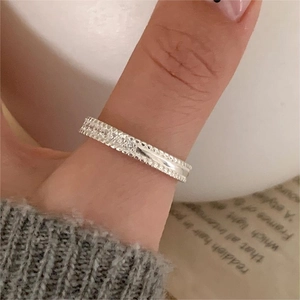 Close-up of a 925 sterling silver ring with sparkling zircon row worn on a finger
