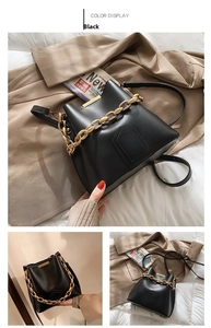 Detail view of black leather bucket bag with gold chain strap and textured surface