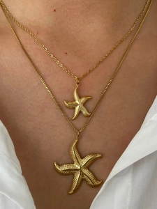 Detail of double-layered 18k gold starfish necklaces with textured starfish pendants