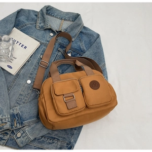 Nahaufnahme der braunen Nylon-Umhängetasche mit Schnallentaschen auf Denim-Jacke