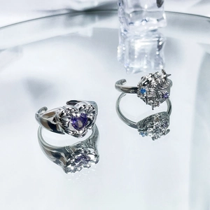 Detailed macro view of silver rings featuring purple heart crystal and textured bands