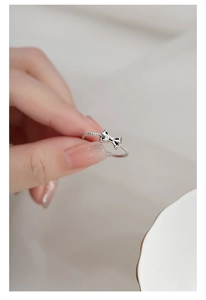 Detail of s925 silver bow ring featuring a twisted rope texture band on a finger