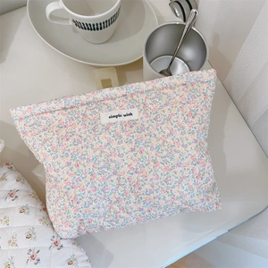 Floral padded makeup bag with 'simple wish' label in a cozy tabletop setting