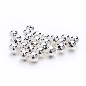 Makroaufnahme glänzender silberner Metallperlen mit glattem Loch für DIY-Schmuck
