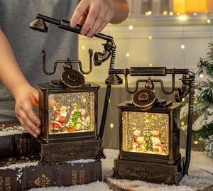 Close-up of bronze vintage phone lantern with Santa and snowman scene inside