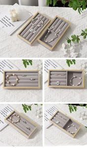 Detailed grid view of grey velvet jewelry trays with elegant acrylic frames and gold trim