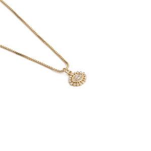 Detailed close-up of gold evil eye pendant with sparkling marquise and round crystals