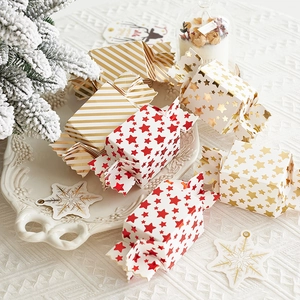 Elegant candy-shaped Christmas gift boxes with gold stars and stripes in a festive setup