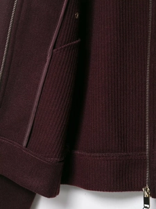 Detailed close-up of dark burgundy wool jacket featuring ribbed knit texture and gold button