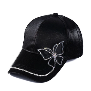 Fashionable black satin baseball cap featuring a large rhinestone butterfly and studded brim