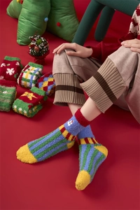 Close-up of thick coral fleece Christmas socks with festive patterns and soft texture