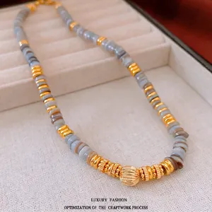 Retro beaded necklace with grey stone beads and a large gold-toned brushed metal centerpiece