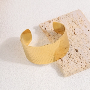 Detail view of gold wide cuff bracelet showing the leaf texture and adjustable opening