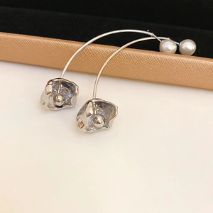 Detail of silver liquid metal earrings with long curved rod and white pearl backing
