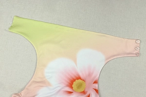 Dettaglio dell'abito con stampa floreale sfumata con motivo tropicale e bottoni traslucidi