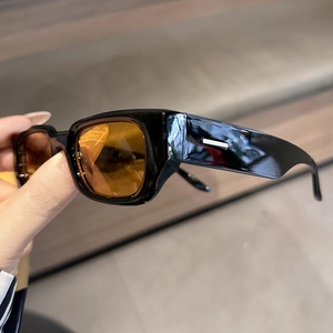 Detail of wide temple retro sunglasses with orange lenses and silver metal accent