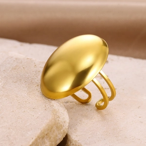 Detailed macro shot of a gold oval dome ring on stone with silk metallic finish texture