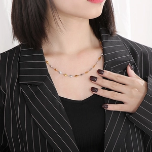Close-up of model wearing a minimalist gold and silver heart link choker necklace