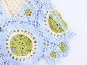Détail macro des motifs floraux au crochet sur le haut camisole bohème tricoté