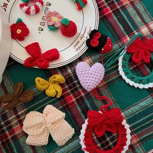 Handmade crochet Christmas tree ornaments and festive DIY knit accessories on a plate