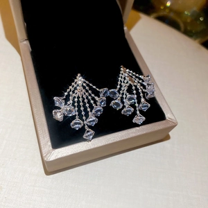 Macro shot of silver tassel earrings with sparkling zircon crystals in a gift box