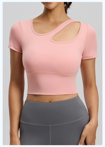 Dettaglio del crop top rosa con taglio asimmetrico e tessuto sportivo traspirante