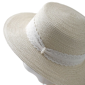 Elegant beige straw boater hat featuring delicate white floral lace and pearl accents