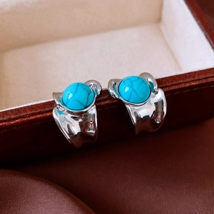 Vue macro de boucles d'oreilles vintage en argent avec pierres turquoise sur cuir